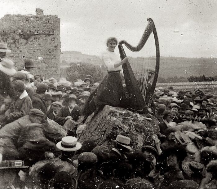 18. Молодая женщина играет на арфе перед большой толпой, Кашельская скала, Ирландия, ок. 1910 г.