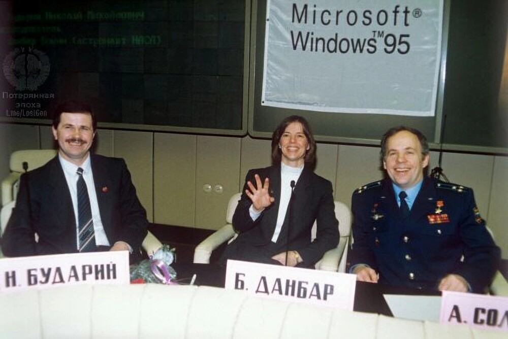 Экипаж космического корабля Союз ТМ-21 на пресс-конференции в Звёздном городке, на фоне рекламы Windows 95