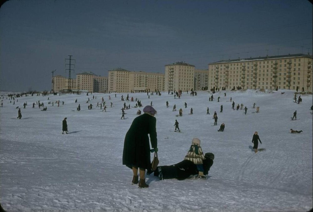Зима в Москве. Детвора и взрослые катаются с горок в парке "Удальцовские пруды" на фоне новых домов, что на улице Кравченко.