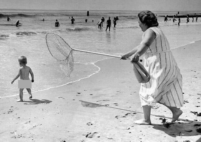 12. Ловля ребенка с помощью сачка на пляже Рокавей, штат Нью-Йорк, 1958 г.