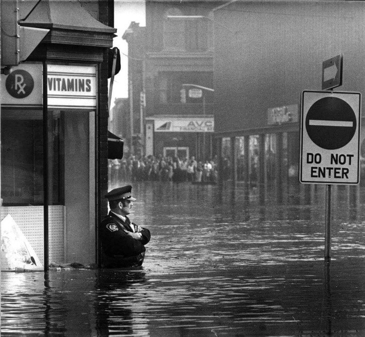 3. Полицейский Джон Шаттлворт, стоящий во время наводнения в Кембридже, Онтарио, 1974 год