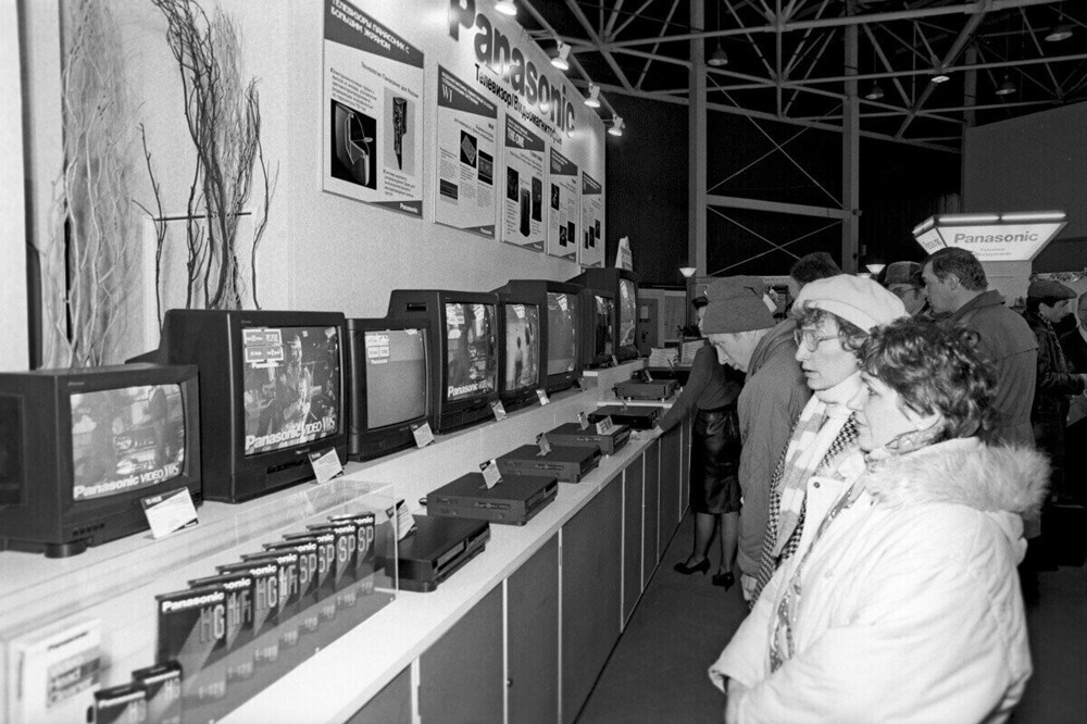 Люди смотрят видеомагнитофоны и телевизоры фирмы «Panasonic». Японская торгово-промышленная выставка на Красной Пресне. Москва, 1992 год.