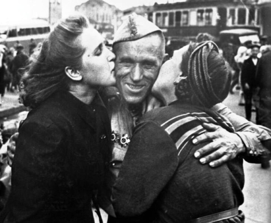 Солдат-победитель в объятиях жены и дочери. 1945 год. Автор: Анатолий Морозов. Москва.