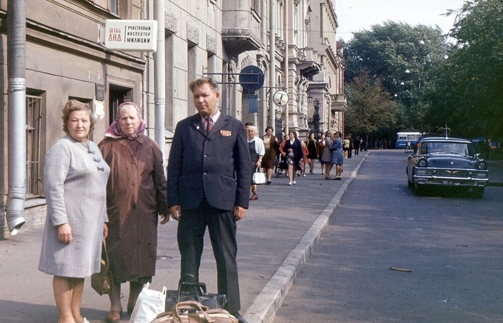 На улице Петра Лаврова (ныне Фурштатская), рядом с дворцом Бракосочетания номер 2. А на заднем плане едет "Чайка" с молодоженами.