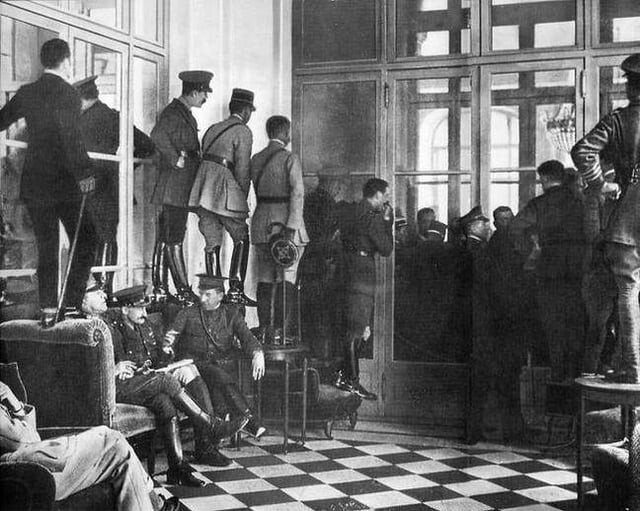 12. Военные и чиновники встали на стулья, столы и диван, чтобы посмотреть на подписание Версальского договора, завершившего Первую мировую войну, 28 июня 1919 года