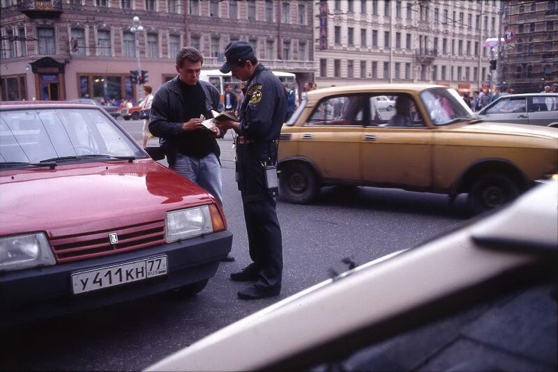 Сотрудник ГАИ проверяет документы. 1995 год. Автор: Всеволод Тарасевич. Санкт-Петербург. Сотрудник ГАИ проверяет документы. 1995 год. Автор: Всеволод Тарасевич. Санкт-Петербург.