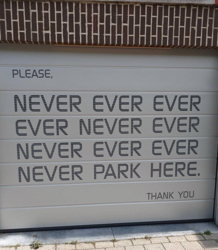 Гаражная дверь в доме напротив. «Пожалуйста, никогда, никогда, никогда, никогда не паркуйся здесь. Спасибо».