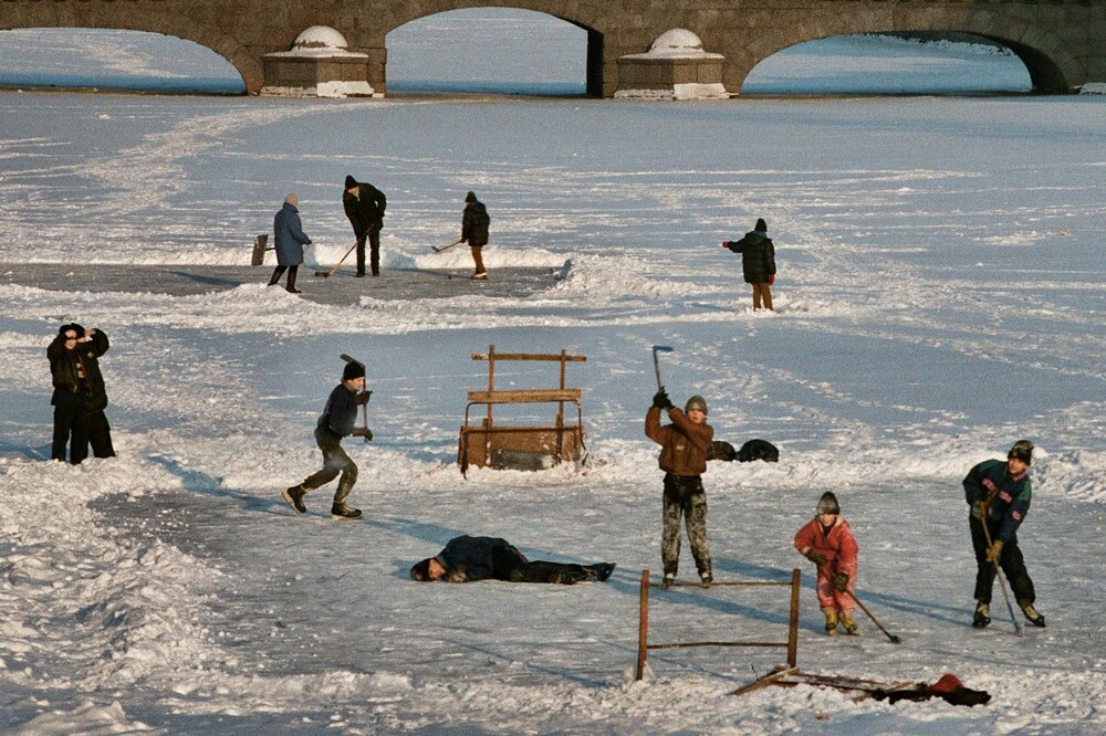 Детвора играет в хоккей на льду Фонтанки. Позади - Измайловский мост.