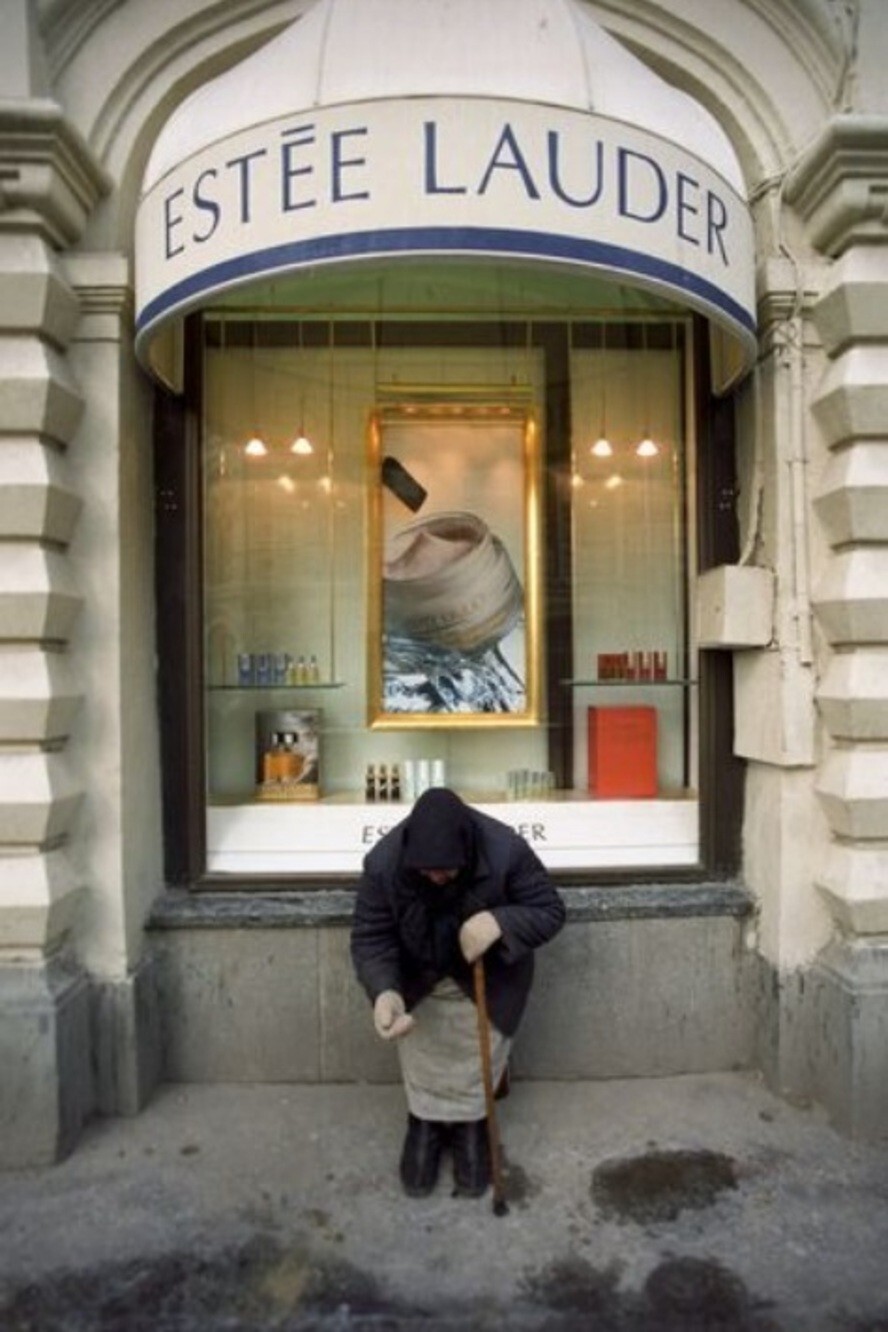 Пожилая женщина просит милостыню у магазина «Estée Lauder» в центре Москвы, 1993 год.