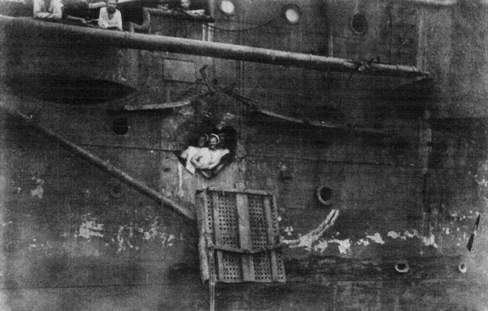 17. Русские моряки у пробоины от японского снаряда в борту крейсера «Олег» после Цусимского сражения, июнь 1905 года. Крейсер получил 12 попаданий, потерял 13 человек убитыми и 31 раненым, но сумел прорваться в нейтральный порт Манилы