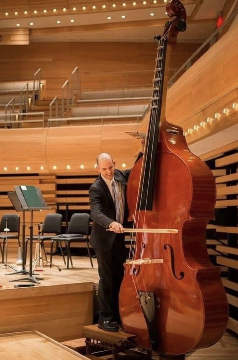 Огромный музыкальный инструмент октобас рядом с человеком