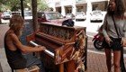 Бездомный мужчина талантливо играет на пианино на улице
