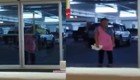 Уборщица пытается вымыть автоматические двери супермаркета 