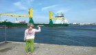 Маленькая девочка, стоящая на пристани, просит посигналить проплывающий корабль