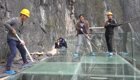 Рабочие с помощью кувалд испытывают на прочность новый стеклянный мост в горах Китая