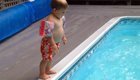 Пытаясь научится прыгать, как мама, маленький мальчик забавно плюхнулся в бассейн