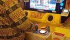 Начинающий геймер и азиат играют в игровой автомат 