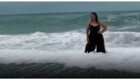 Попытка женщины сделать красивую фотографию на фоне моря