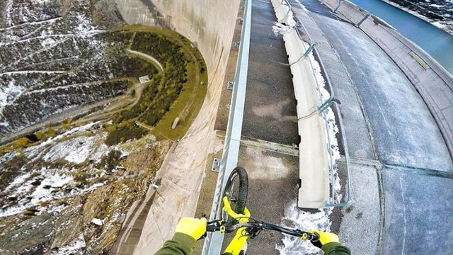  А ты знаешь, что такое безумие? 21-летний экстремал балансирует на своём велосипеде на перилах 200-метровой дамбы