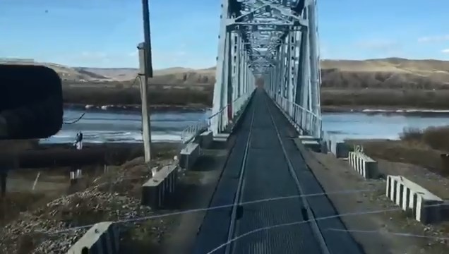 Недовольный водитель едет по железнодорожному мосту