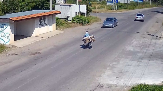 Дедушка на велосипеде с макулатурой