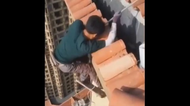 Бесстрашный китайский рабочий игнорирует технику безопасности на большой высоте