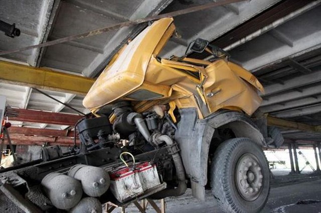 Самосвал с поднятым кузовом застрял под эстакадой лесокомбината