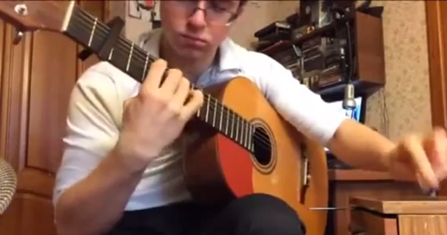 Играет одной рукой на гитаре