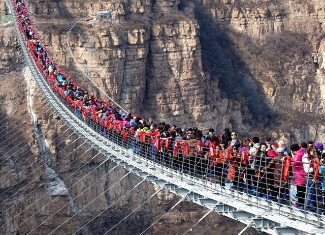 Сотни бесстрашных туристов столпились на самом длинном стеклянном мосту в мире