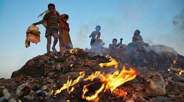 Бангладешские дети просеивают горящие груды мусора, чтобы найти что-то ценное для продажи
