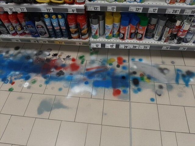 Люди тестируют баллончики с краской прямо на полу магазина
