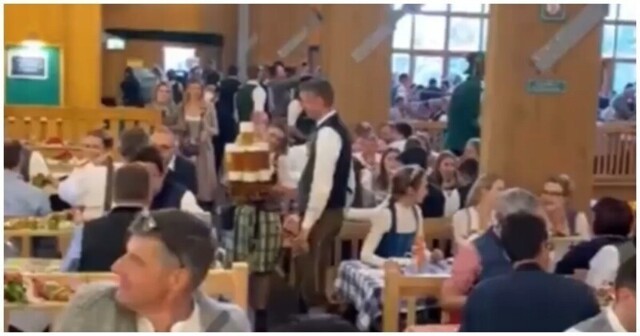 Немецкая официантка разносит бокалы с пивом на Октоберфесте