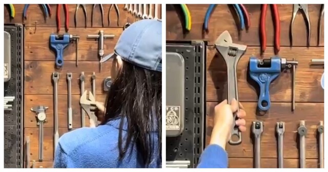 Девушка пытается повесить разводной ключ на стену