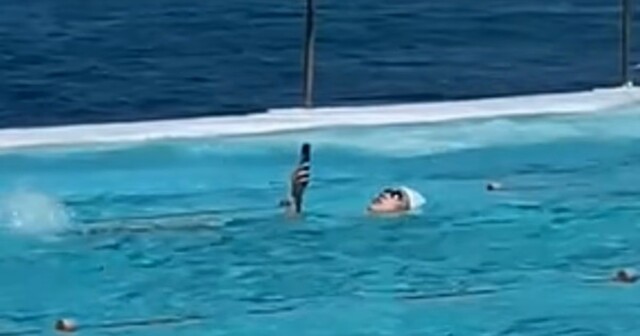 "Самое антиутопичное зрелище": женщина устроила заплыв с телефоном в руке